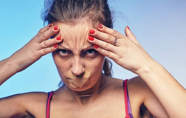 Jonge vrouw met zijn mond gelijmd met tape. — Stockfoto