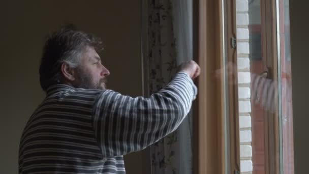 Un hombre feliz abre la ventana para sentir el clima — Vídeo de stock