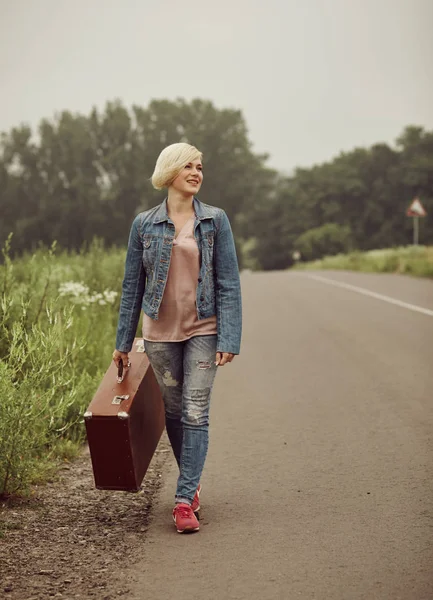 Traveler girl with a suitcase on the road. — 图库照片