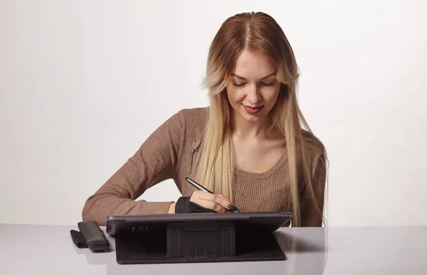 Dziewczyna artysta rysuje cyfrowy długopis na profesjonalnym tablecie w jej studio — Zdjęcie stockowe