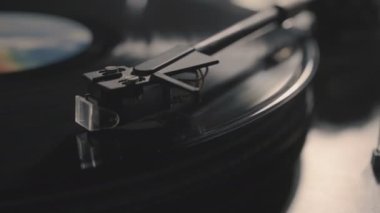 Oyuncu, vinil plak çalarken stil iğnesi atıyor