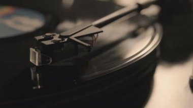 Oyuncu, vinil plak çalarken stil iğnesi atıyor
