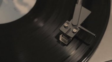 Oyuncu, vinil plak çalarken stil iğnesi atıyor