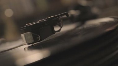Oyuncu, vinil plak çalarken stil iğnesi atıyor