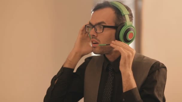 Επιχειρηματίας διερμηνέας δάσκαλος φορώντας ακουστικά κοιτάζοντας τις σημειώσεις οθόνη του φορητού υπολογιστή — Αρχείο Βίντεο