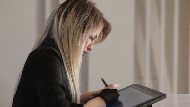 Ragazza artista disegna una penna digitale su un tablet professionale nel suo studio — Video Stock