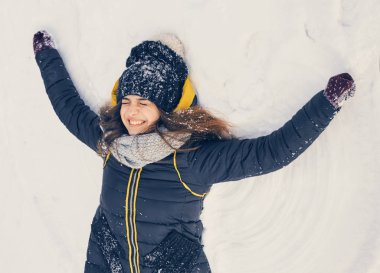 happy smiling young girl lying in the snow clipart