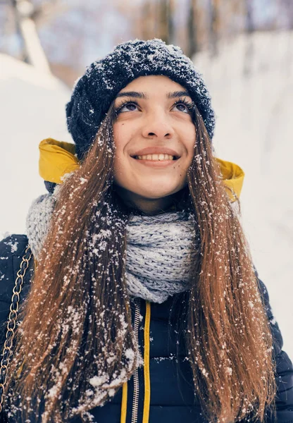 Kış portresi, örgü örülmüş, karla kaplı bir züppe giyen güzel bir kadın. Kar yağan kış güzellik moda konsepti — Stok fotoğraf