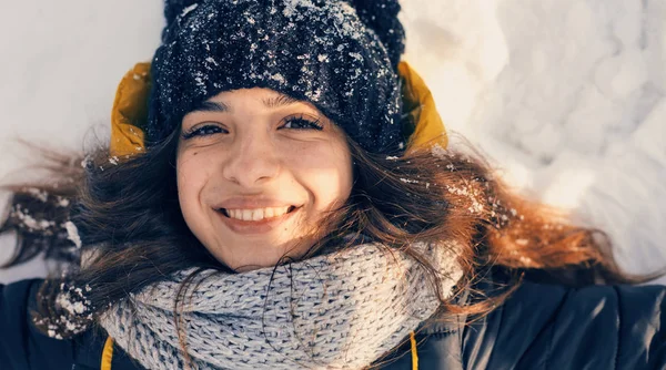 Happy smiling young girl lying in the snow — Stock Photo, Image