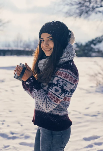 幸福的年轻女人，一杯热茶，下雪的冬天就在大自然中漫步。冬季霜的概念 — 图库照片