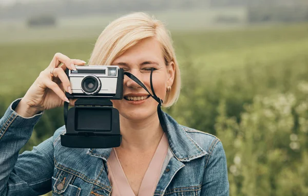 Mulher tirando foto em um campo de flores — Fotografia de Stock