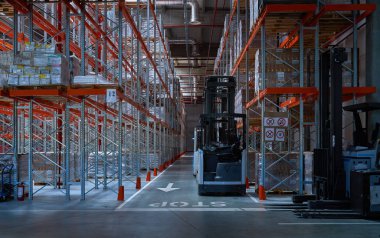 Forkliftlerle dolu modern bir depo.