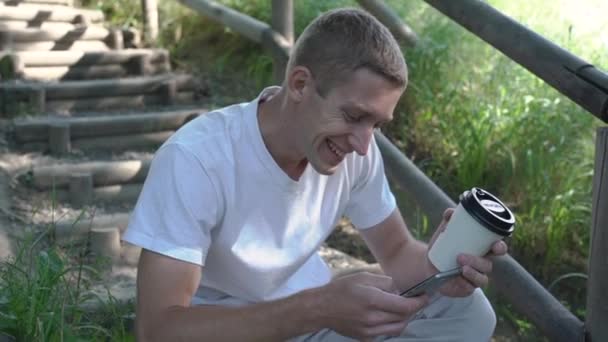 Portrait of a man using mobile phone, holding device, texting, surfing internet, and using app. — Stock Video