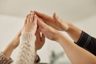 a success and winning concept - happy business team giving high five in office
