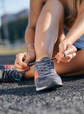 Woman getting ready for jogging workout. Closeup of running shoes.