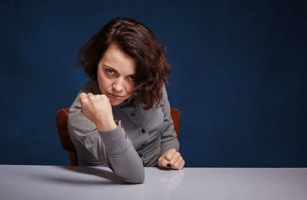 Porträt einer Frau in aggressiver Stimmung vor dunkelblauem Hintergrund — Stockfoto