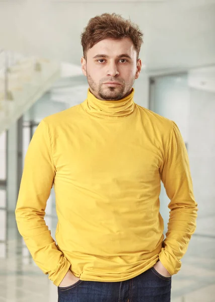 A portrait of young business man in yellow golf in office — Stock Photo, Image