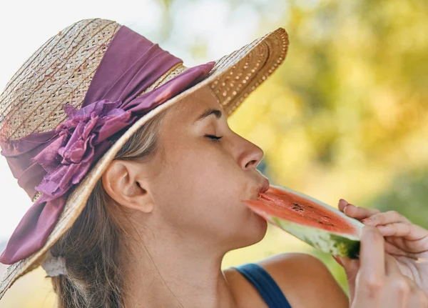 Mooie vrouw eten watermeloen in de zomer in park — Stockfoto