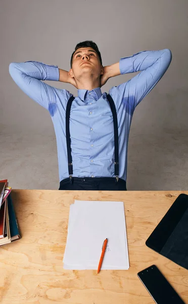 Een ontspannen zelfverzekerde jonge zakenman zit met benen op het bureau — Stockfoto