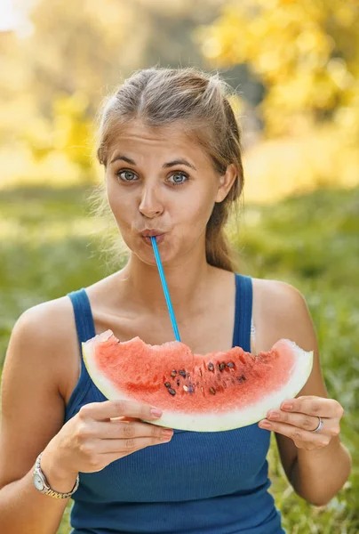 Žena pití meloun přes koktejl trubice — Stock fotografie
