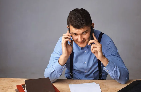 Man met twee telefoons in de buurt van zijn oren. Hij beslist actief iets. — Stockfoto