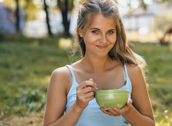 Portrait of happy smiling young woman eating noodles — 图库照片