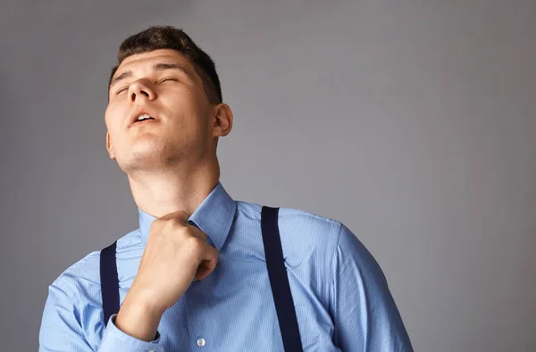 Jovem empresário cansado e tentando desabotoar sua camisa — Fotografia de Stock