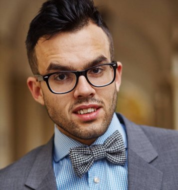 Gözlüklü ve kelebekli genç bir adamın portresi.