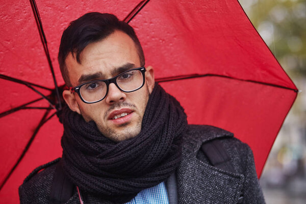 businessman goes in the rain with umbrella