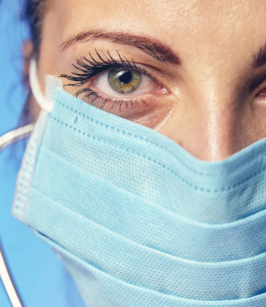 doctors face close-up in a surgical cap and armband.