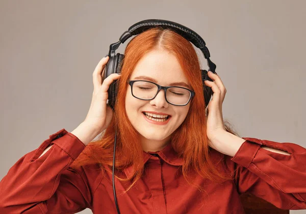 Очень счастливая молодая девушка слушает музыку в наушниках — стоковое фото