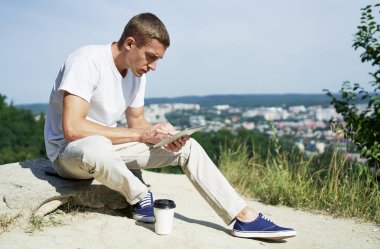 Adam çalışırken dışarıda dijital tablet tutuyor.