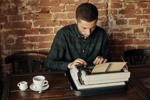 Young man writing on old typewriter. — Stock Photo, Image