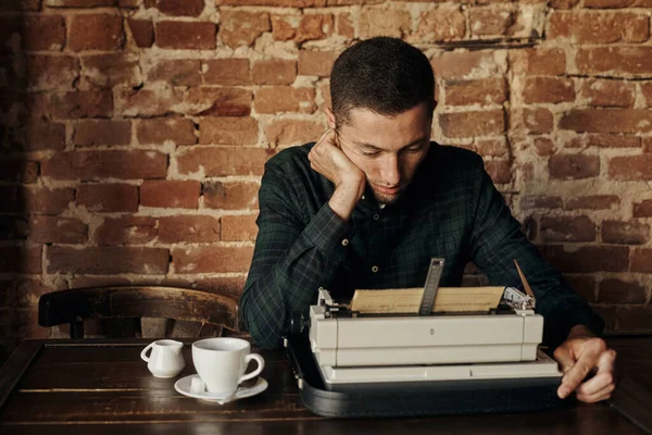 Junger Mann schreibt auf alter Schreibmaschine. — Stockfoto