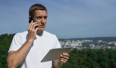 Genç adam tabletine bakıyor. Birisi telefondan arıyor. Endişeli.