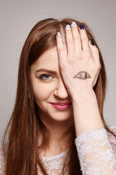 Брюнетка женщина с нарисованными глазами на руке, как символ нечестной игры и двойных стандартов жесты, язык тела, психология концепции — стоковое фото