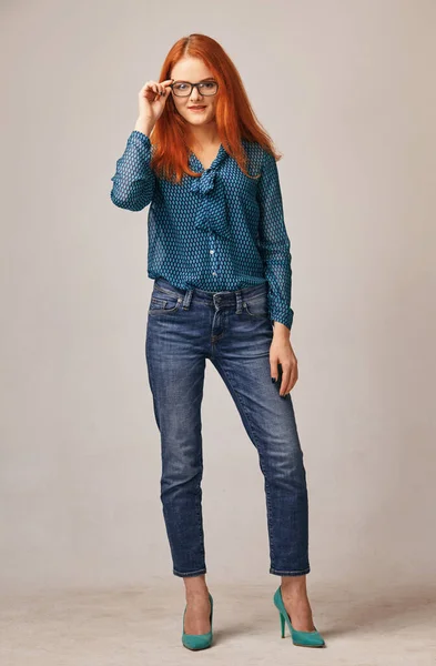 Portrait of young red-haired beauty in blouse and jeans — Stock Photo, Image