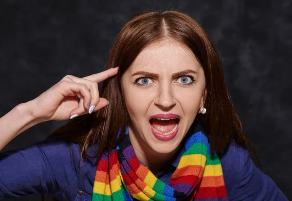 Geschokte jonge vrouw wijzend naar haar tempel — Stockfoto