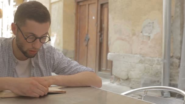 Jonge man die een boek gaat lezen — Stockvideo