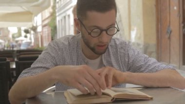 Genç adam kitap okumak üzere.