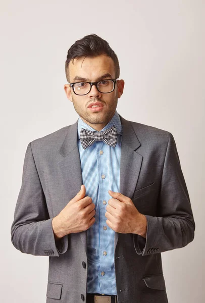 Retrato de estudio de un joven con una camisa azul con una mariposa y gafas . —  Fotos de Stock