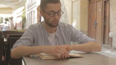 Genç adam kitap okumak üzere.