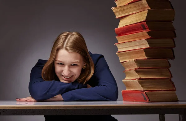 Portret van jong mooi meisje in de buurt van stapel boeken. glimlacht ze. — Stockfoto