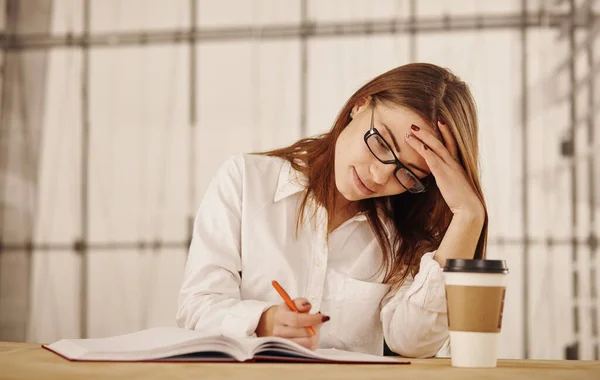 Een jonge zakenvrouw die in functie schrijft. — Stockfoto