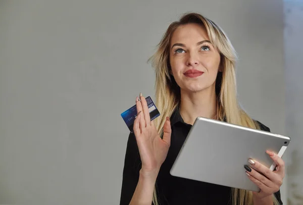 Młoda kobieta z karty kredytowej zakupy na cyfrowe tabletki podczas leżenia w domu — Zdjęcie stockowe