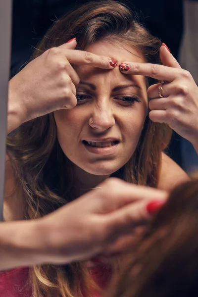 Jong mooi meisje kijken naar zichzelf in de spiegel — Stockfoto