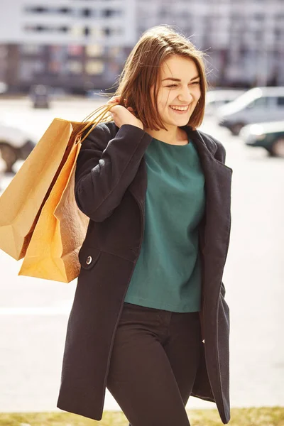 在城市里带购物袋的微笑女孩 — 图库照片