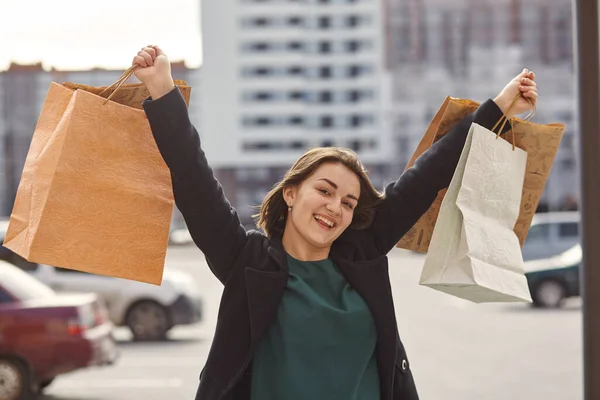 Menina sorridente com sacos de compras em uma cidade — Fotografia de Stock