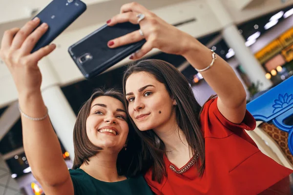Två kvinnor möts och kramas, de är glada och tar selfies — Stockfoto