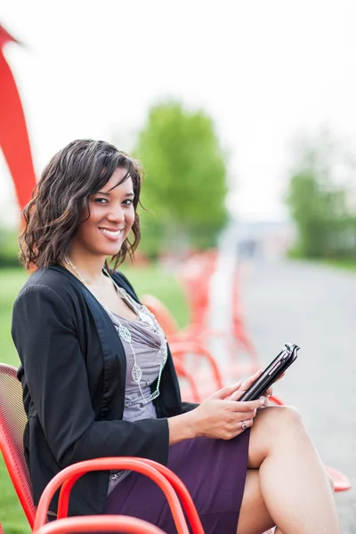 African American businesswoman reading on her tablet PC at an ou — Stock Photo, Image
